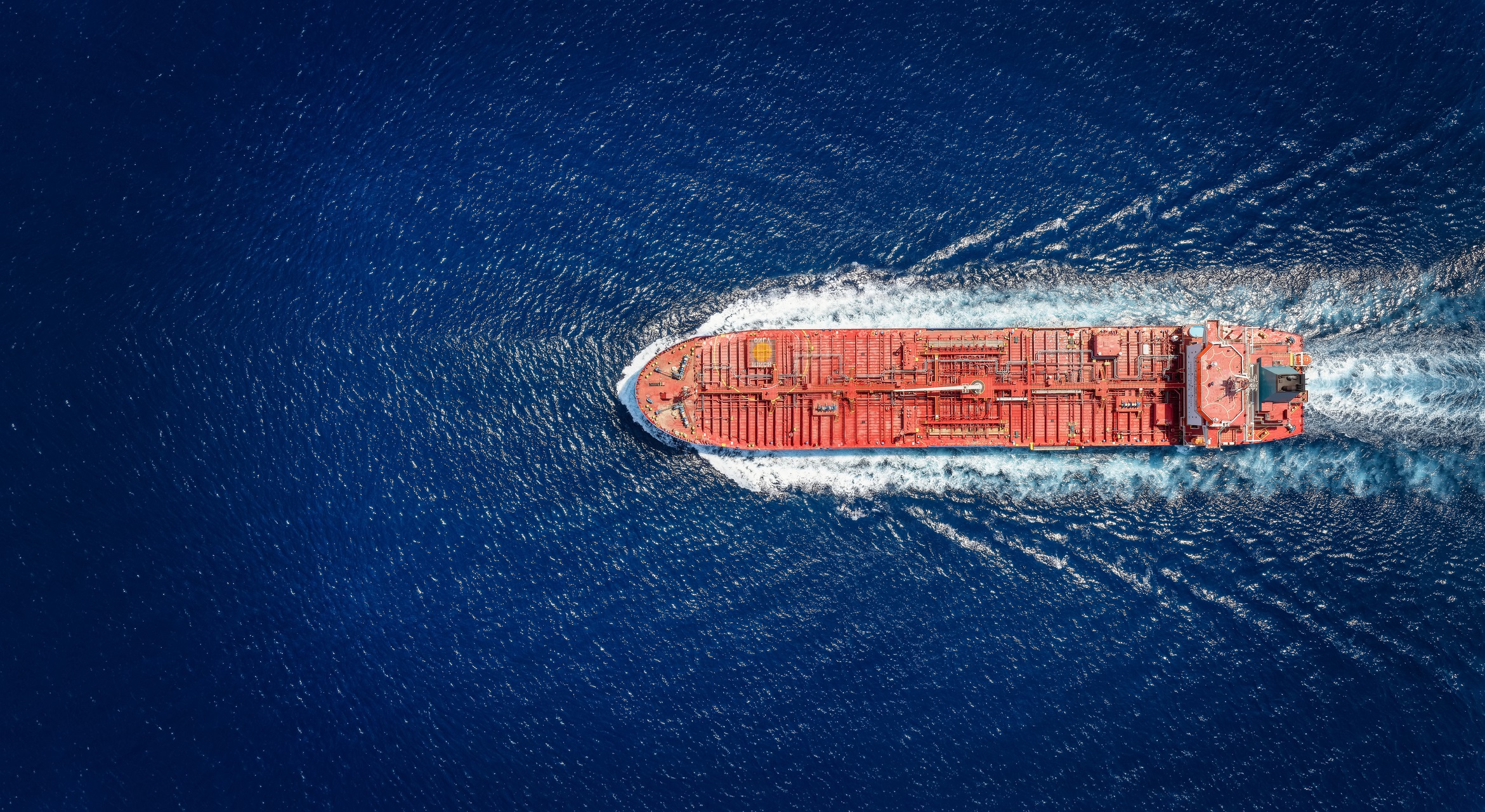 High aerial top view of a crude oil tanker traveling with speed over the ocean