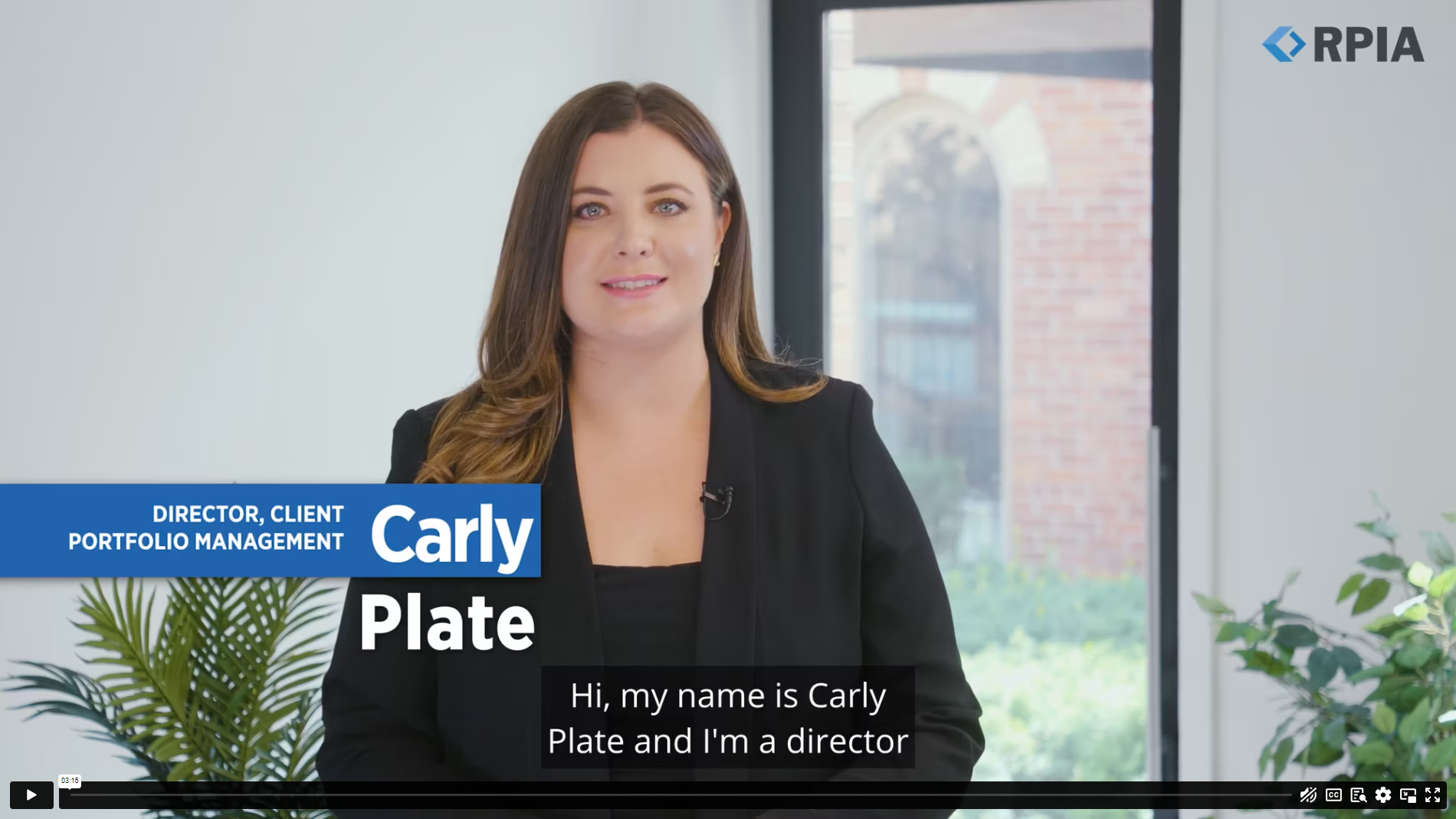 Carly Plate standing in front of a window with plants in the background